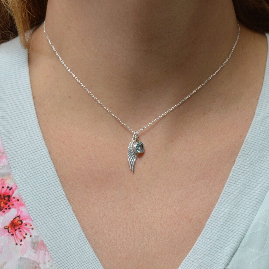 Silver angel wing and blue topaz birthstone necklace